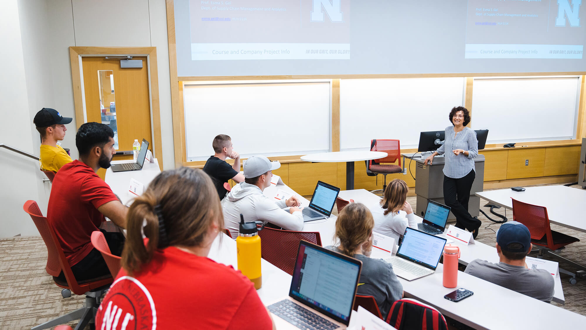 Students in classroom listen to female professor's lecture.