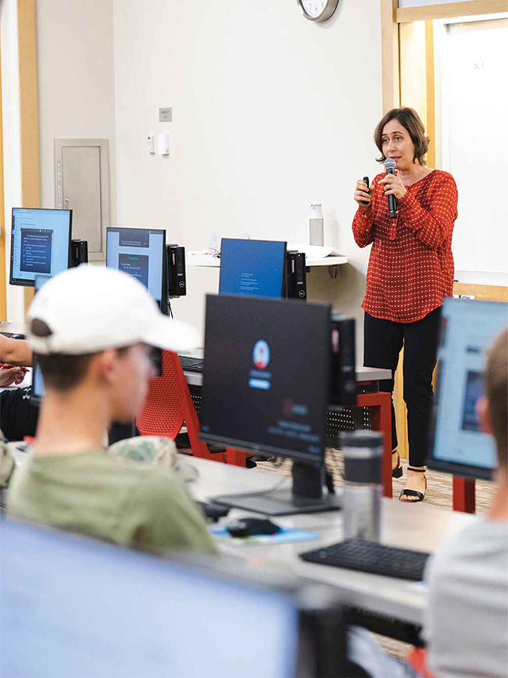 Students in classroom listen to female professor's lecture.